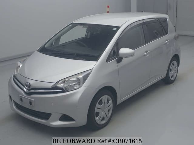 A grey sports car speeding down a highway at night.