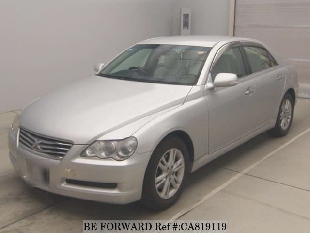 A grey JDM sports car speeding down a highway at night.