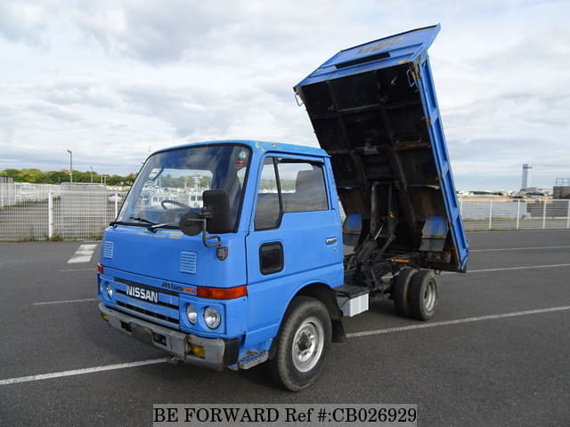 A grey JDM sports car speeding down a highway at night.