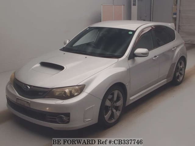 A grey JDM sports car speeding down a highway at night.