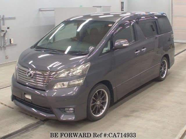 A grey JDM sports car speeding down a highway at night.