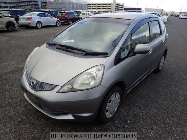 A grey JDM sports car speeding down a highway at night.
