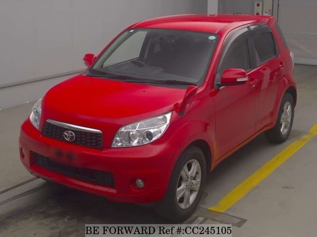 A grey sports car speeding down a highway at night.