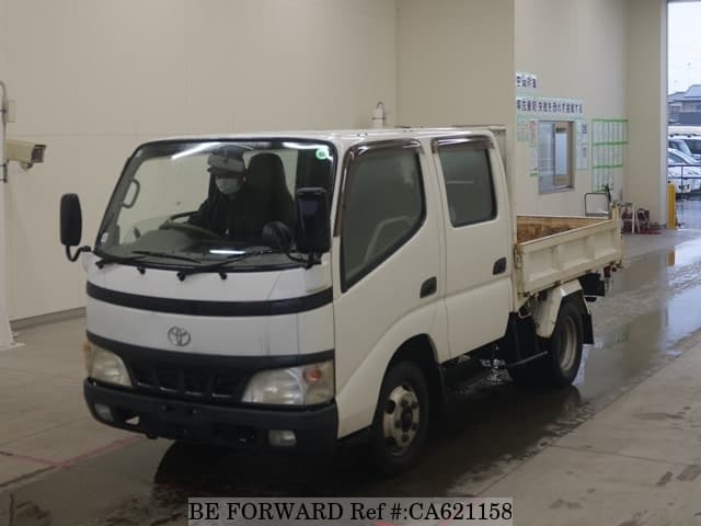 A grey JDM sports car speeding down a highway at night.
