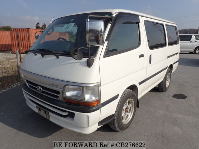 A grey JDM sports car speeding down a highway at night.