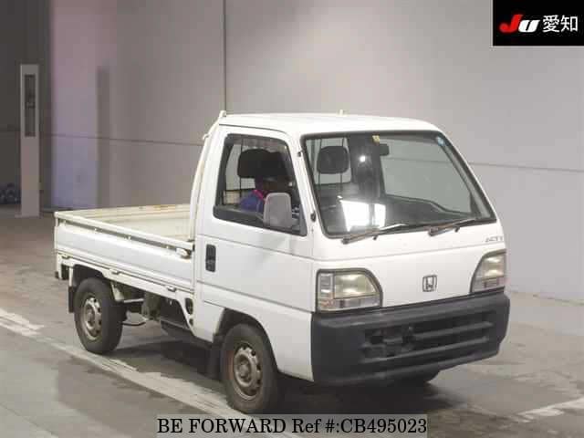 A grey JDM sports car speeding down a highway at night.