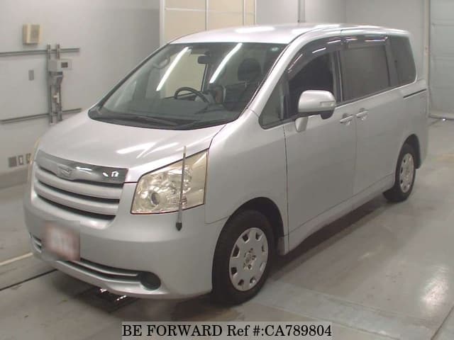 A grey JDM sports car speeding down a highway at night.
