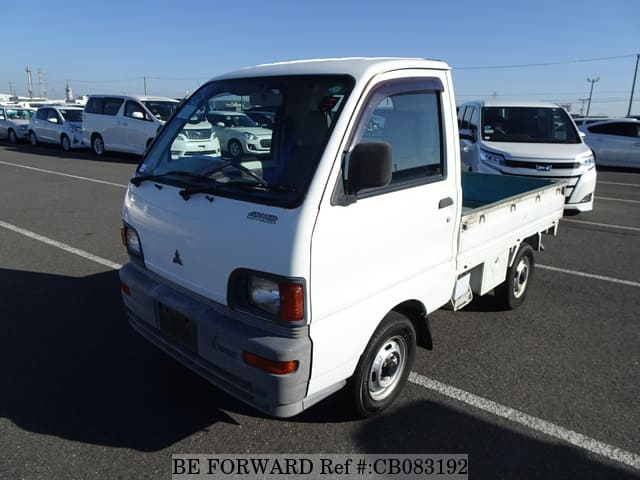 A grey JDM sports car speeding down a highway at night.