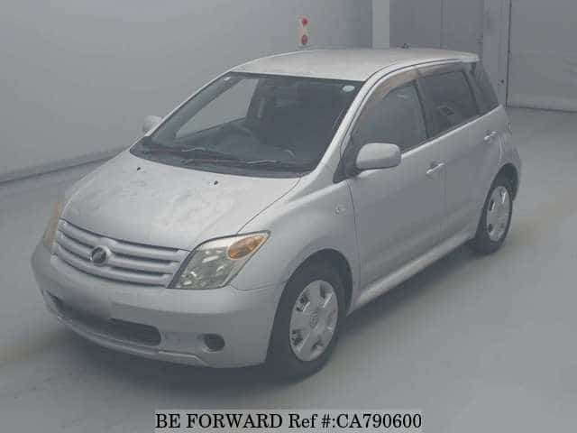 A grey JDM sports car speeding down a highway at night.