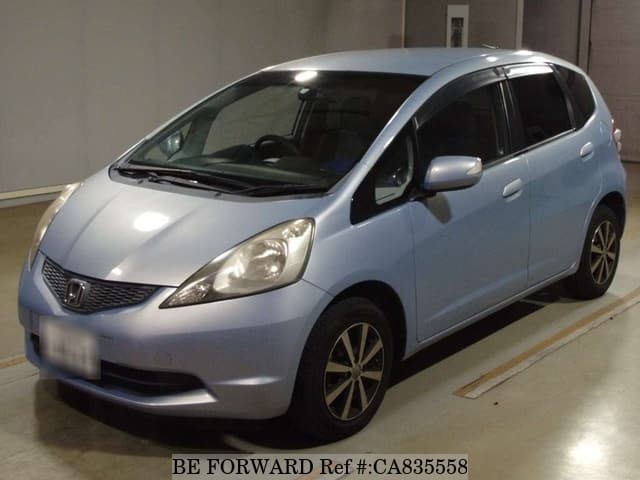 A grey JDM sports car speeding down a highway at night.