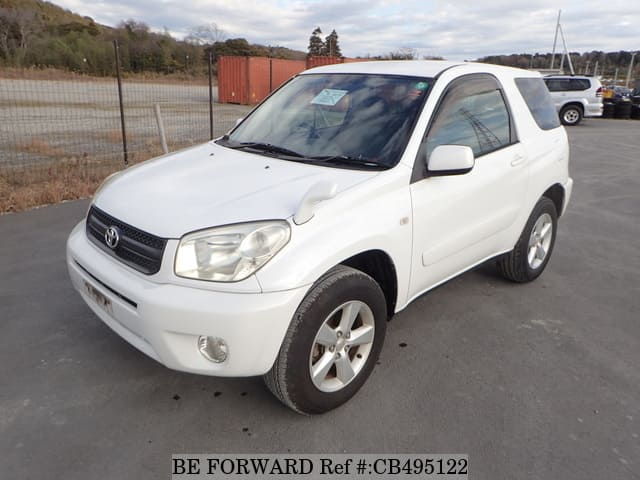 A grey JDM sports car speeding down a highway at night.