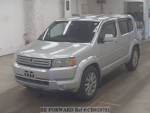 A grey JDM sports car speeding down a highway at night.