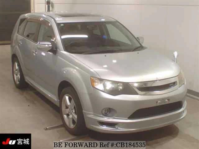 A grey JDM sports car speeding down a highway at night.