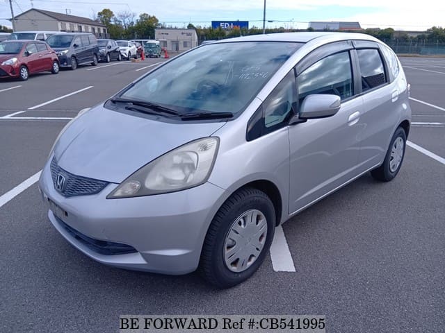 A grey JDM sports car speeding down a highway at night.