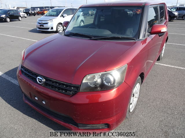 A grey sports car speeding down a highway at night.