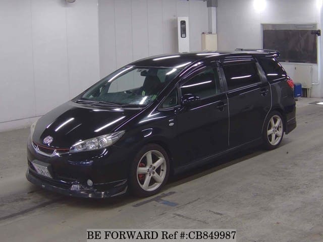 A grey JDM sports car speeding down a highway at night.