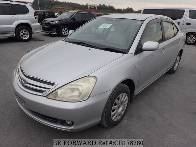 A grey sports car speeding down a highway at night.