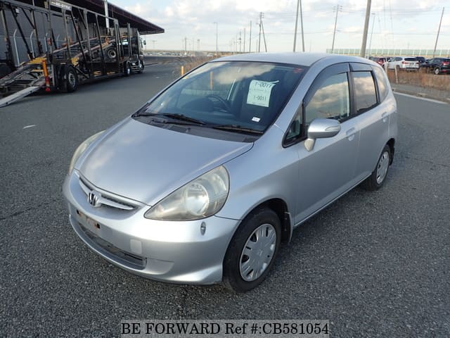 A grey JDM sports car speeding down a highway at night.