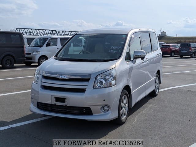 A grey sports car speeding down a highway at night.