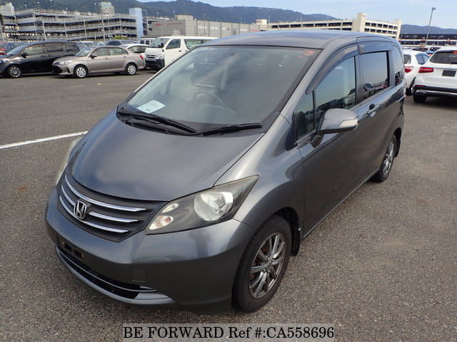 A grey JDM sports car speeding down a highway at night.