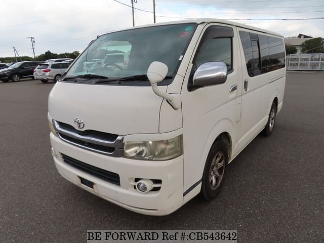 A grey sports car speeding down a highway at night.