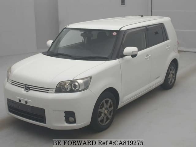 A grey JDM sports car speeding down a highway at night.