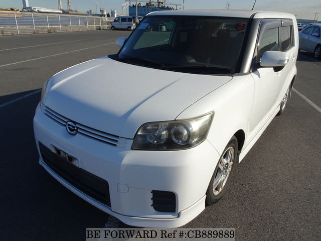A grey JDM sports car speeding down a highway at night.