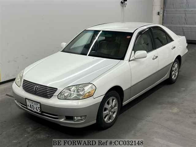 A grey sports car speeding down a highway at night.