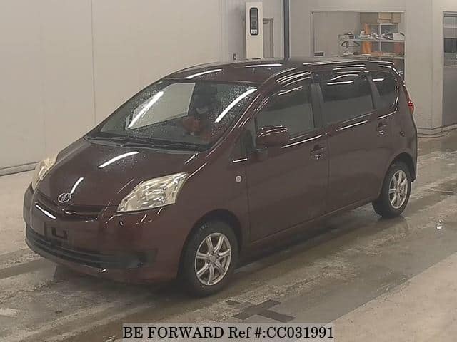 A grey sports car speeding down a highway at night.