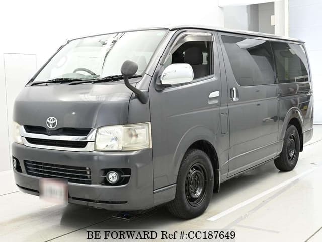 A grey sports car speeding down a highway at night.