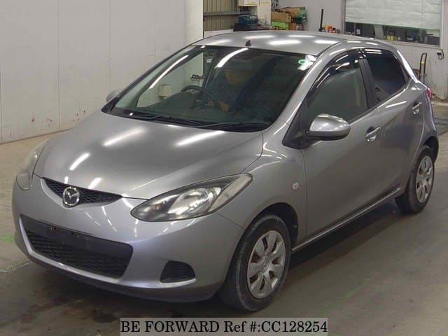 A grey sports car speeding down a highway at night.