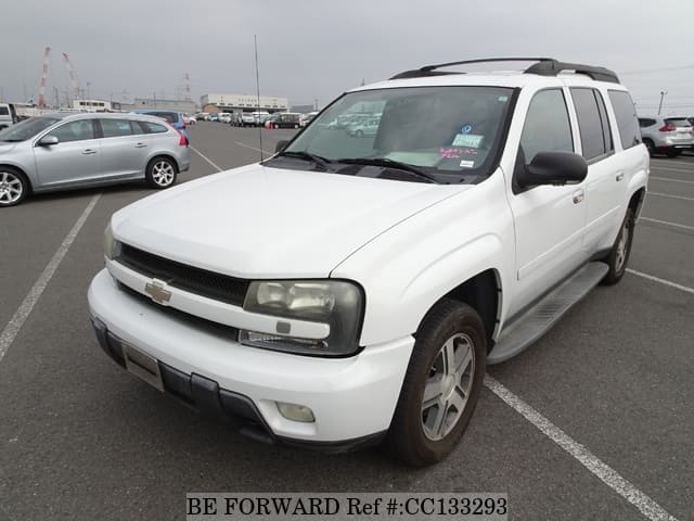 A grey sports car speeding down a highway at night.
