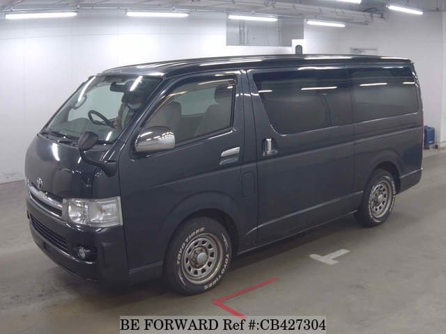 A grey JDM sports car speeding down a highway at night.