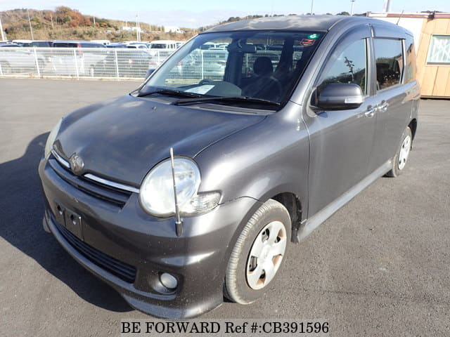 A grey JDM sports car speeding down a highway at night.