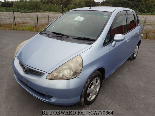 A grey JDM sports car speeding down a highway at night.
