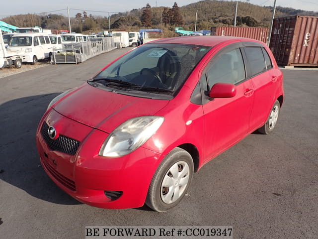 A grey sports car speeding down a highway at night.