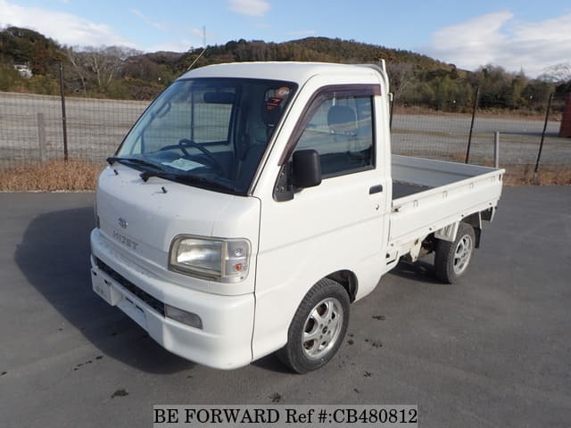 A grey JDM sports car speeding down a highway at night.