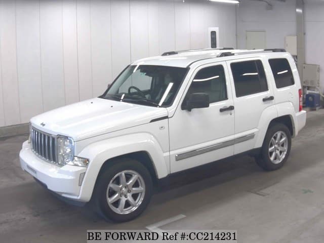 A grey sports car speeding down a highway at night.