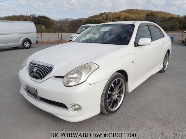 A grey JDM sports car speeding down a highway at night.