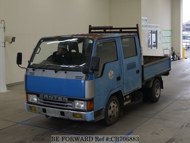 A grey JDM sports car speeding down a highway at night.