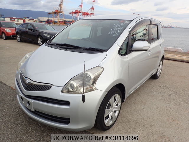 A grey JDM sports car speeding down a highway at night.