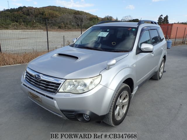 A grey JDM sports car speeding down a highway at night.