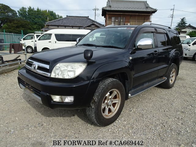 A grey JDM sports car speeding down a highway at night.