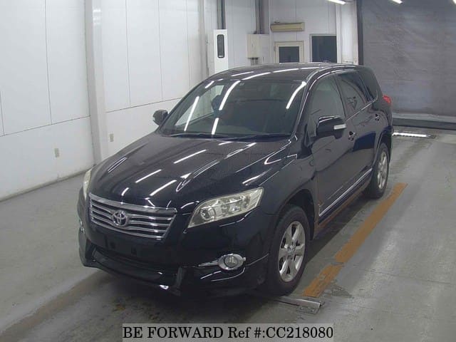 A grey sports car speeding down a highway at night.
