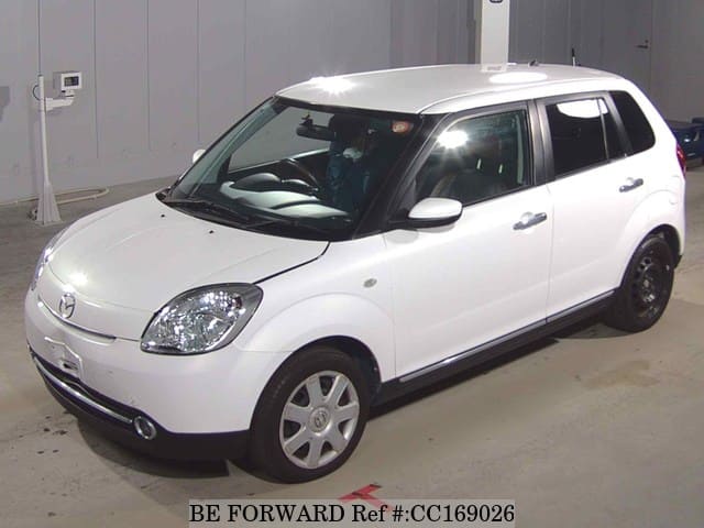 A grey sports car speeding down a highway at night.
