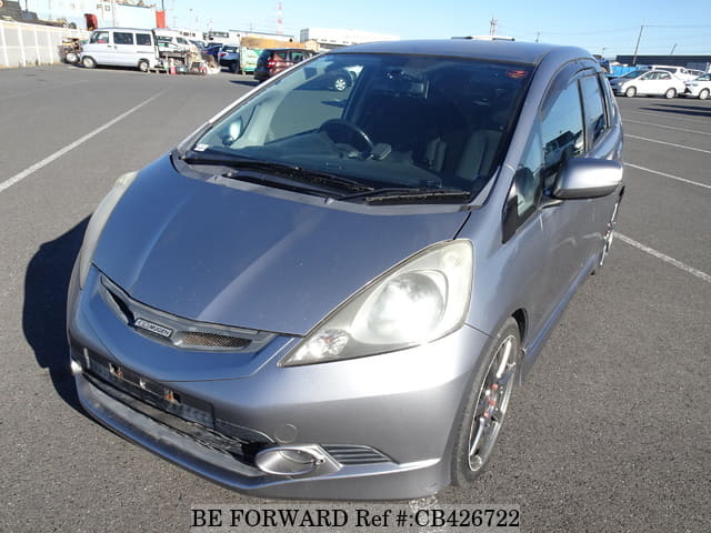 A grey JDM sports car speeding down a highway at night.
