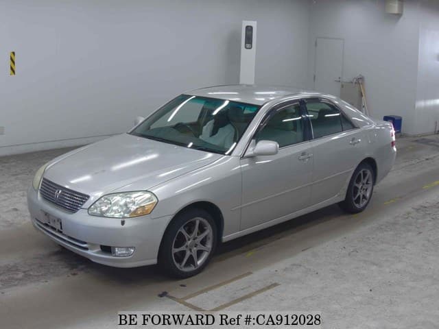 A grey JDM sports car speeding down a highway at night.