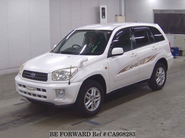 A grey JDM sports car speeding down a highway at night.