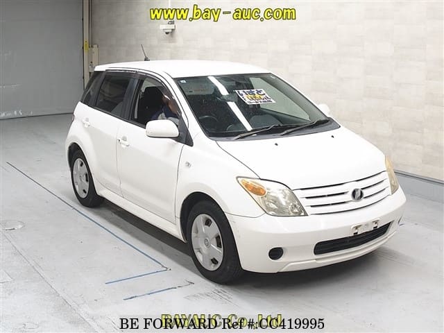 A grey sports car speeding down a highway at night.