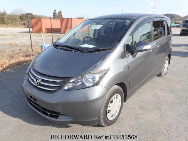 A grey JDM sports car speeding down a highway at night.